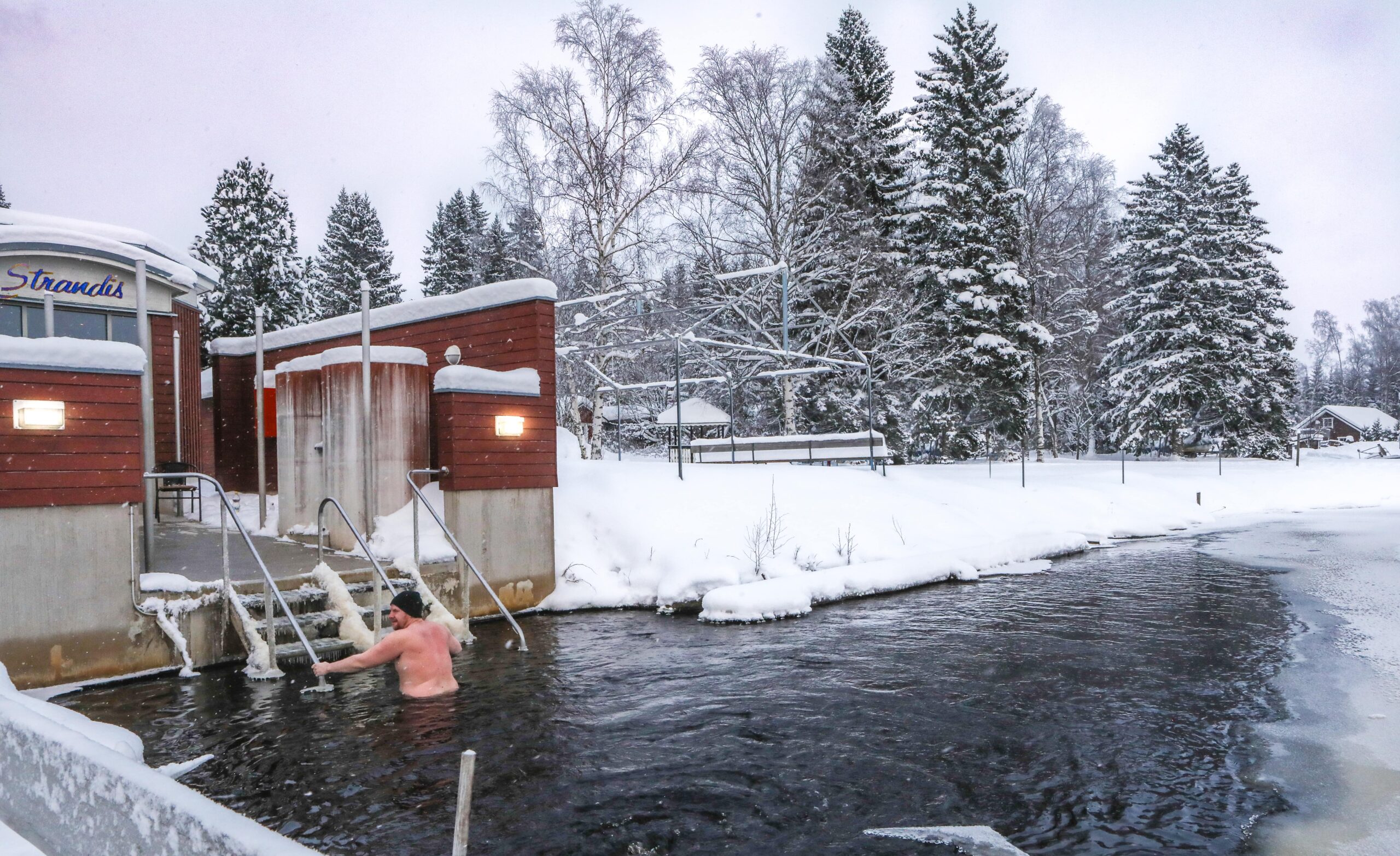 Winter bathing beside the Strandis lakeside sauna in the snow